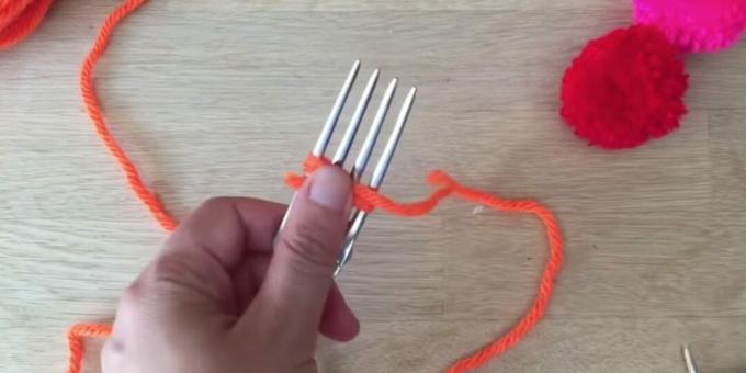 Hoe maak je een pompon: begin met het omwikkelen van de vork met draad