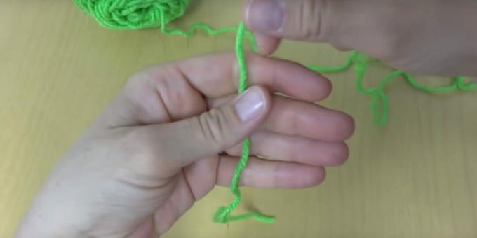 Hoe maak je een pompon: doe een touwtje over je handpalm