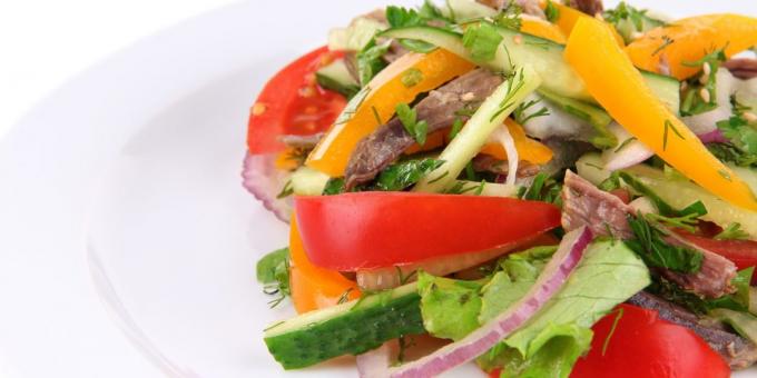 Salade van komkommers, tomaten en rundvlees met uien, knoflook en kruiden