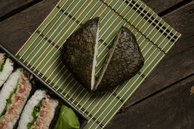 Klassieke onigirazu sushi sandwich: verwijder de folie en verdeel de onigirazu doormidden