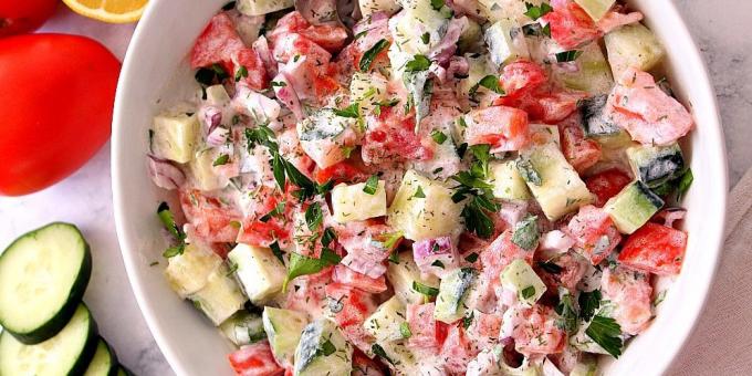 Salade met komkommers en tomaten met uien en zure room dressing