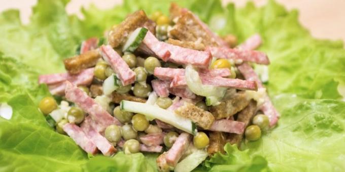 Salade met groene erwten, worst en crackers