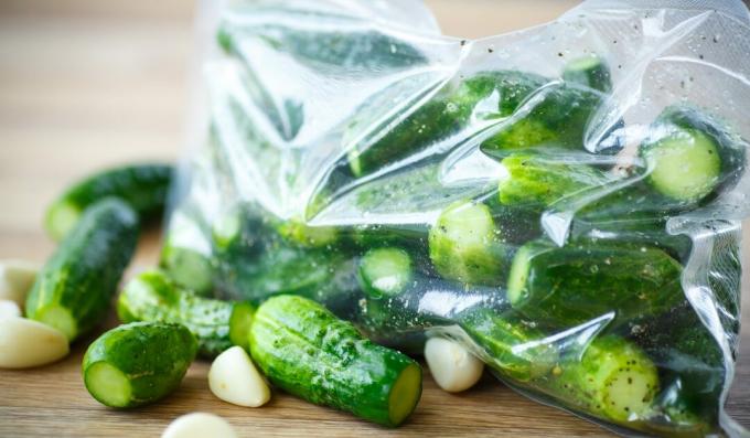 Licht gezouten komkommers in een zakje met knoflook, dille en hete peper