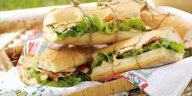Caesar salade met kip en prosciutto in een sandwich