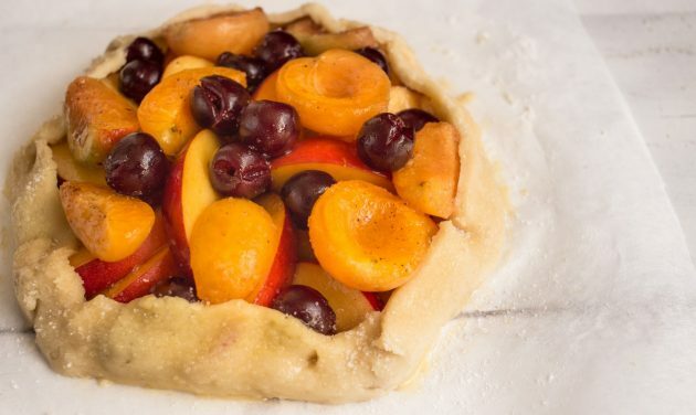 Zandkoek met bessen en fruit: bestrijk de randen met een ei en bestrooi met een snufje suiker