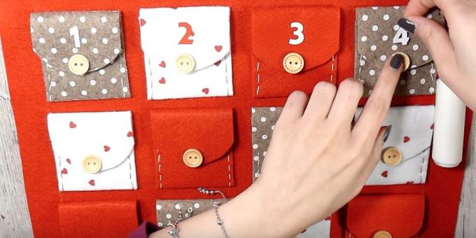 Adventskalender met je eigen handen: Lijm de flappen op de zakken en knoppen en cijfers