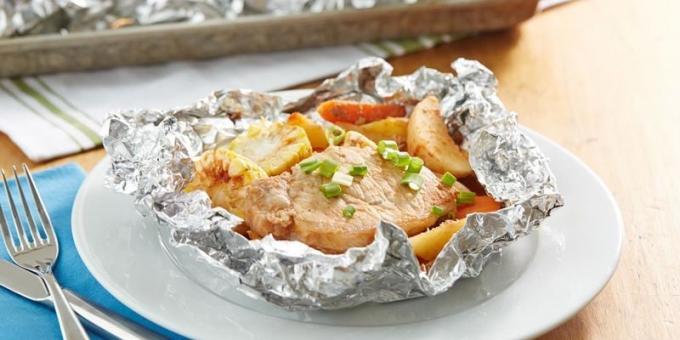 Varkensvlees met aardappelen en maïs in folie in de oven